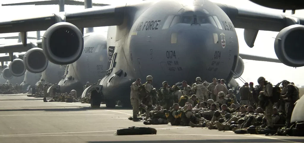 Amerykańscy spadochroniarze ze 173. Brygady Powietrznodesantowej przygotowują się do wejścia na pokład samolotów C-17 Globemaster III w ramach wsparcia operacji "Iracka Wolność" 23 marca 2003 roku w bazie lotniczej Aviano we Włoszech.