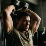 Ćwiczenia na triceps – moc uderzenia zaczyna się od ramion Zdjęcie atlety podczas wykonywania ćwiczeń na triceps z wolnymi ciężarami na siłowni.