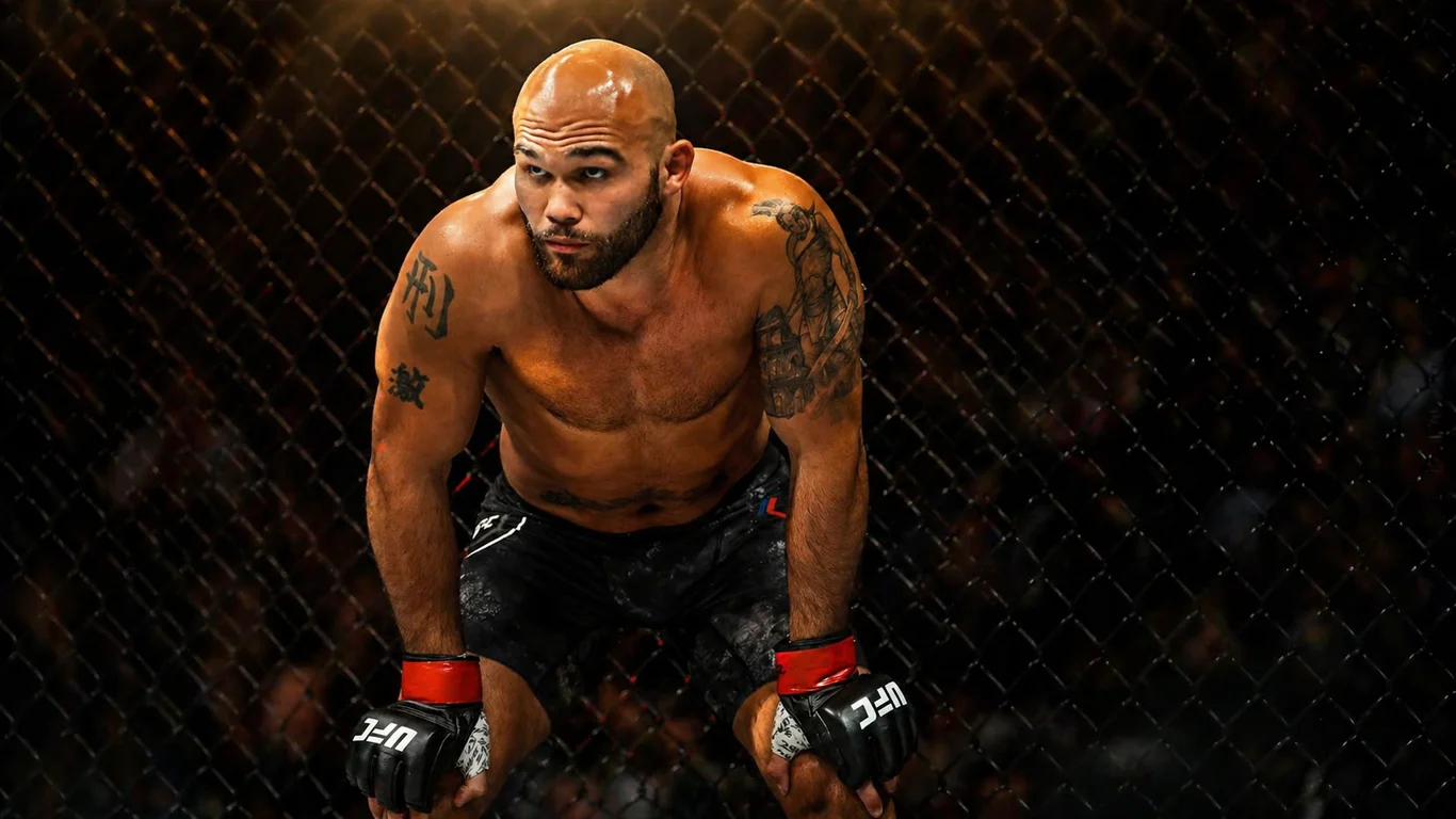 Robbie Lawler w klatce UFC podczas mistrzowskiej walki, z opaską na ręku i dramatycznym oświetleniem oktagonu.