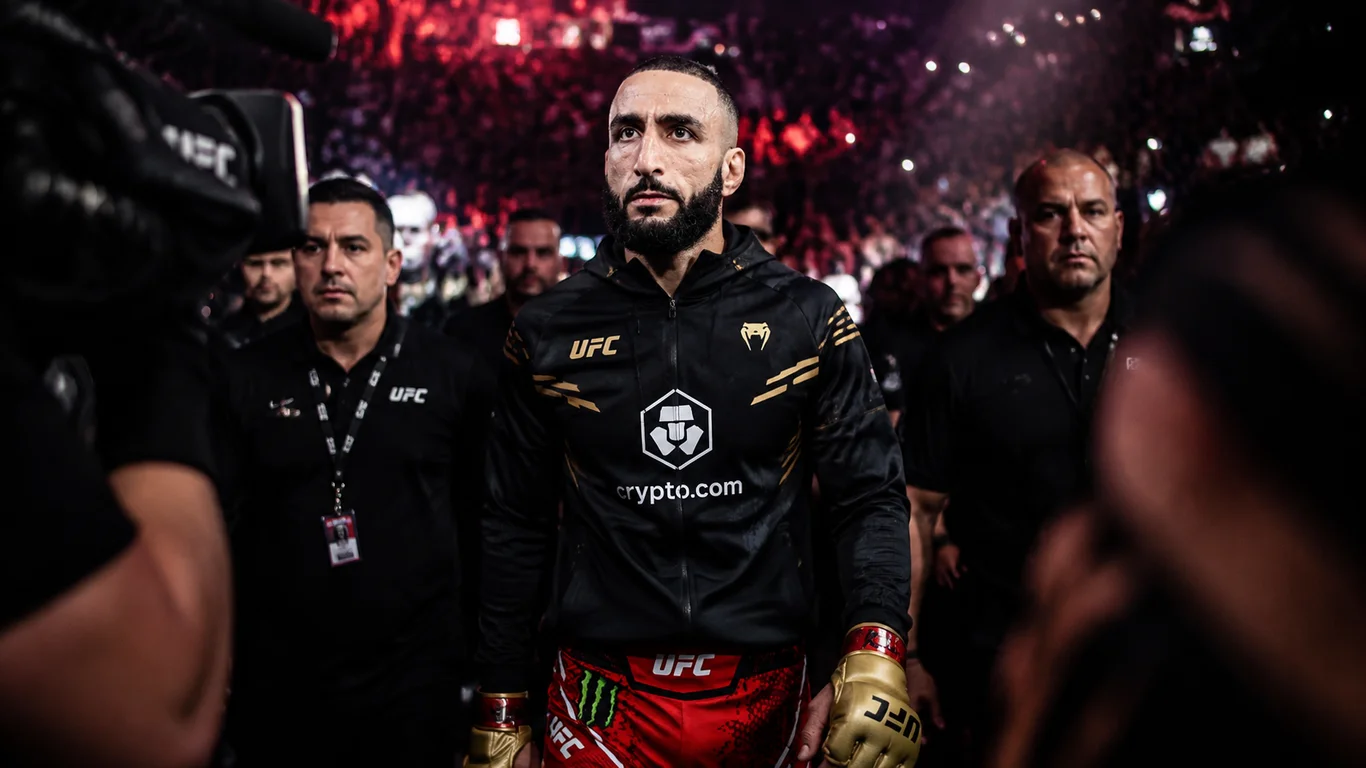Belal Muhammad w oktagonie UFC z pasem mistrzowskim wagi półśredniej i flagą palestyńską w tle.