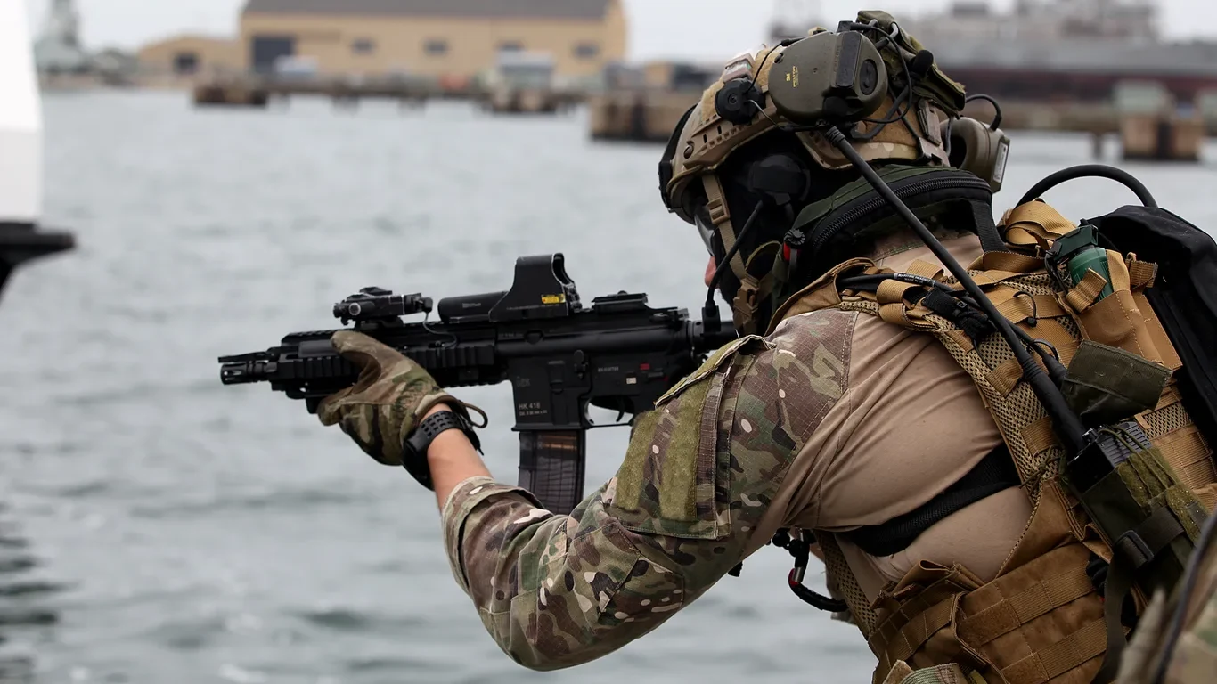 Operator jednostki GROM w oporządzeniu taktycznym z karabinkiem HK416 ubezpiecza sektor nad wodą