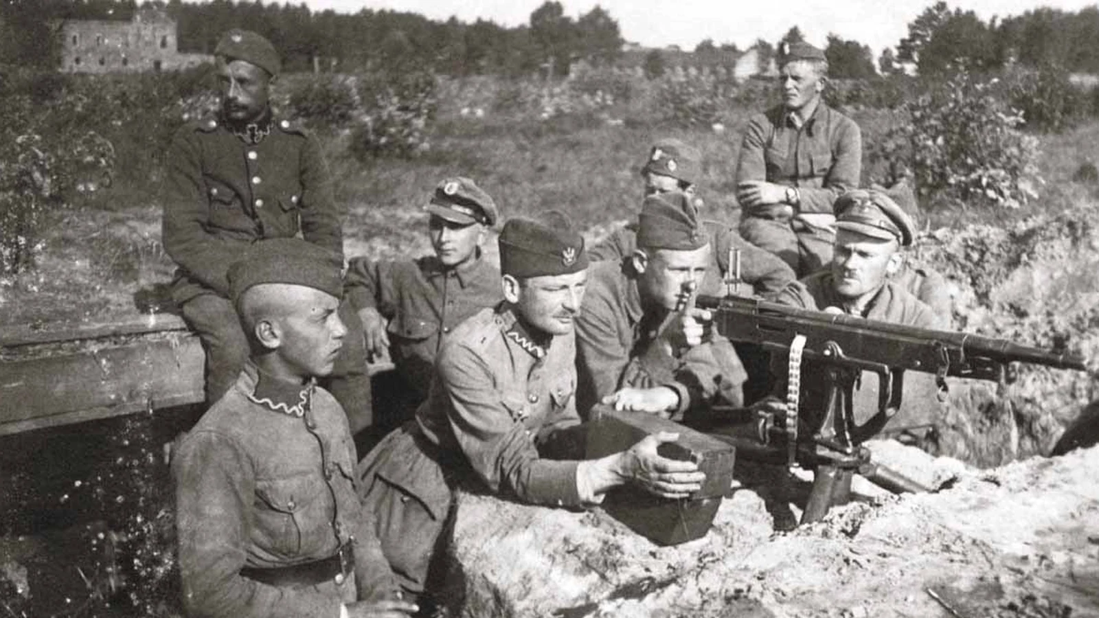 Polska obsługa ciężkiego karabinu maszynowego w okopie pod Warszawą, sierpień 1920 roku – siedmiu żołnierzy w rogatywkach przy stanowisku ogniowym