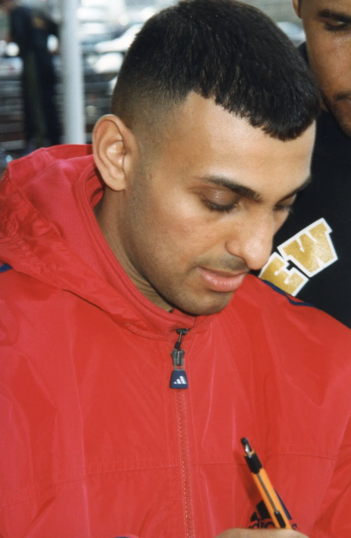 Naseem Hamed w czerwonej kurtce podpisuje autografy dla kibiców
