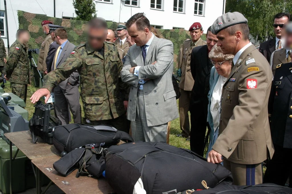 Oficer w berecie z naszywką Ranger ogląda wyposażenie operatorów rozłożone na stole podczas pokazu jednostki