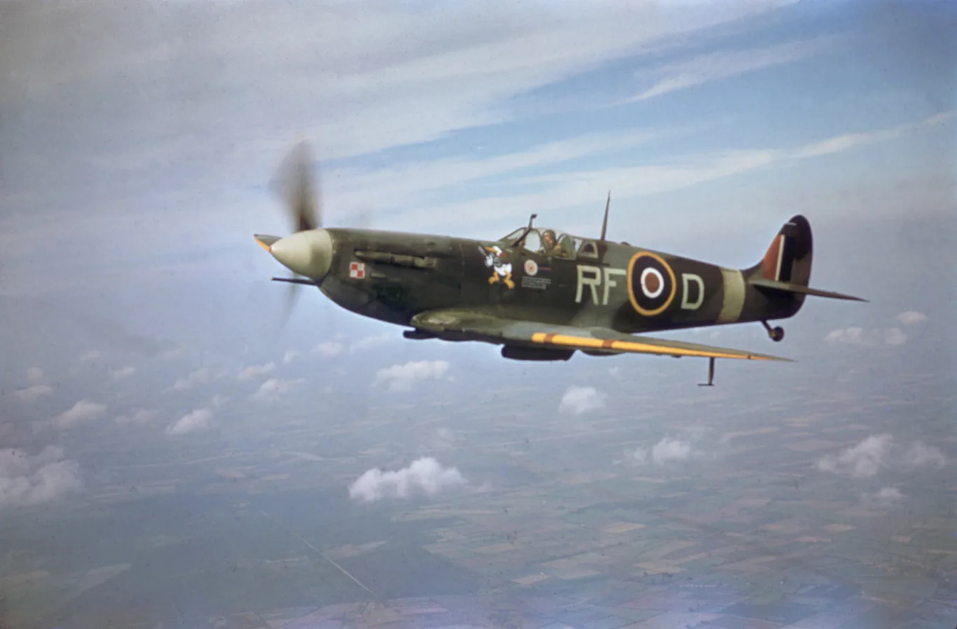 Spitfire Mk Vb z kodem RF-D i wizerunkiem Kaczora Donalda na kadłubie w locie nad chmurami