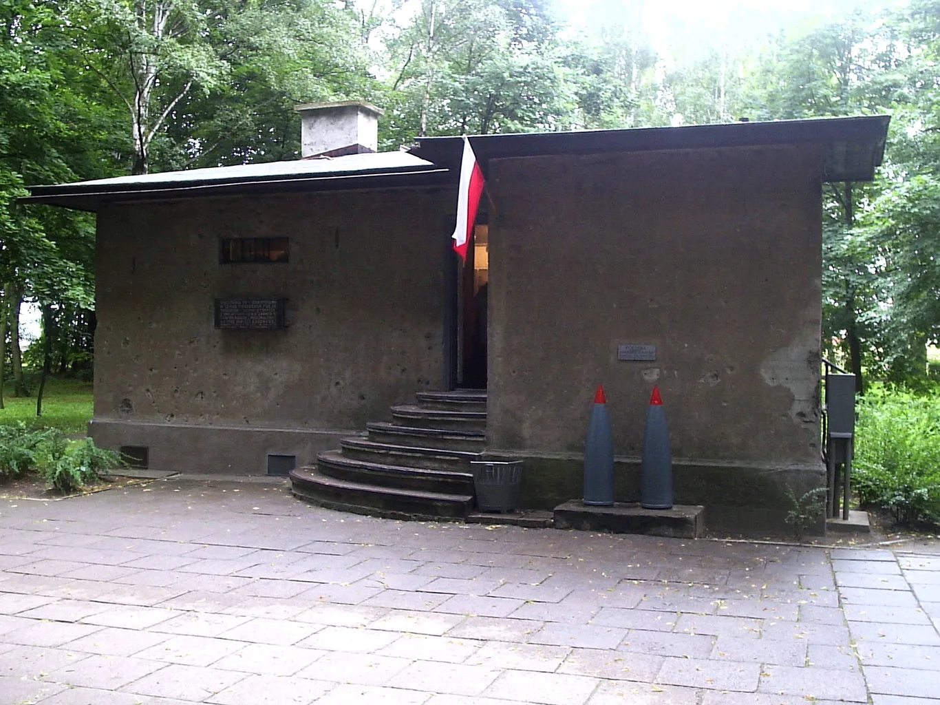 Żelbetowa wartownia nr 1 na Westerplatte z widocznymi śladami po odłamkach i flagą Polski przy wejściu
