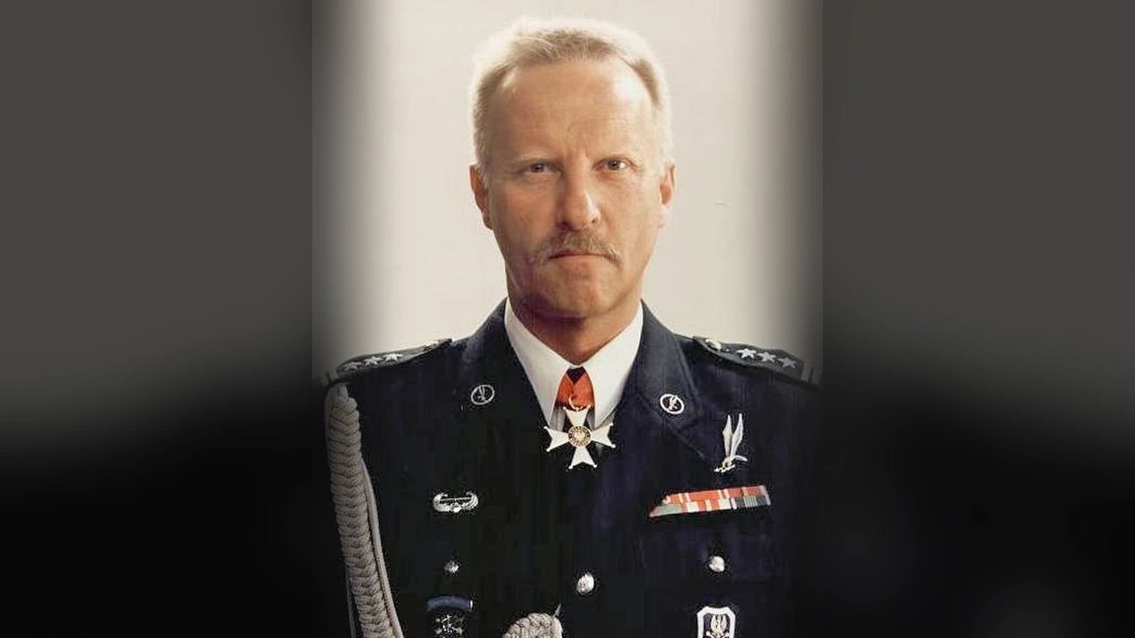 Sławomir Petelicki w ciemnym mundurze galowym ze sznurem galowym i Krzyżem Komandorskim Orderu Odrodzenia Polski przy kołnierzu