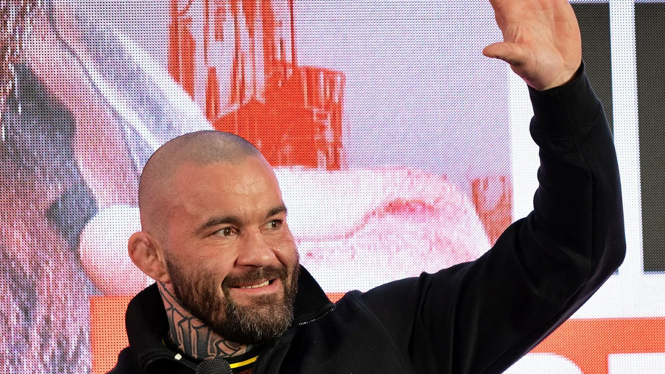 Michał Materla w czarnej bluzie macha ręką do kibiców podczas ceremonii ważenia przed galą Oktagon 86 w Szczecinie
