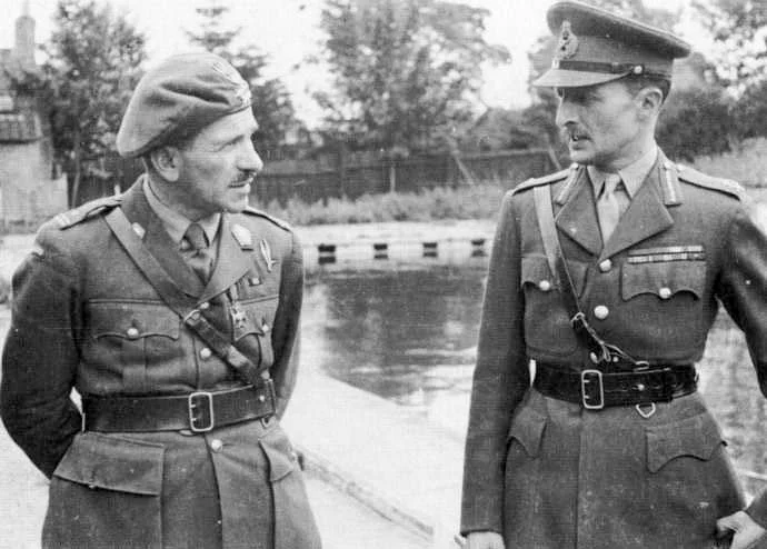 Gen. Stanisław Sosabowski w berecie i mundurze polowym rozmawia z wysokim brytyjskim generałem Frederickiem Browningiem w czapce z daszkiem