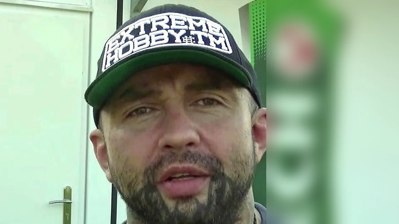 Marcin Różalski w czarnej czapce z daszkiem, z gęstą brodą, udziela wywiadu na zapleczu gali
